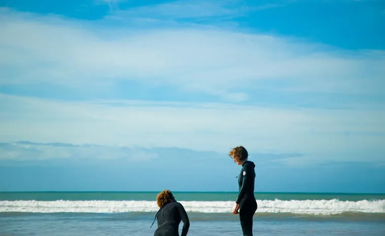 Beginner surfers walking into the whitewater